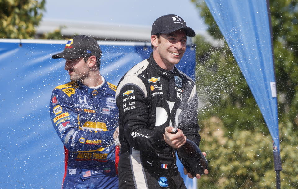 Simon Pagenaud, right, of France, celebrates in the Winner's Circle after taking first place at the Honda Indy auto race in Toronto, Sunday, July 14, 2019. (Mark Blinch/The Canadian Press via AP)