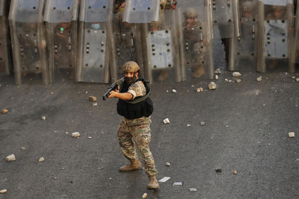 A Lebanese soldier fires rubber bullets during a clash with supporters of Prime Minister-designate Saad Hariri who stepped down on Thursday in Beirut, Lebanon, Thursday, July 15, 2021. Hariri says he is stepping down nine months after he was named to the post by parliament. He is citing "key differences" with the country's president, Michel Aoun. (AP Photo/Hussein Malla)