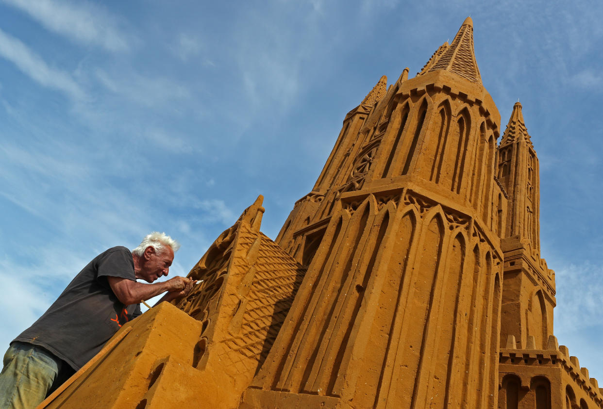 A sand carver works on a sculpture during the Sand Sculpture Festival "Dreams" in Ostend, Belgium June 18, 2019. (Photo: Yves Herman/Reuters)