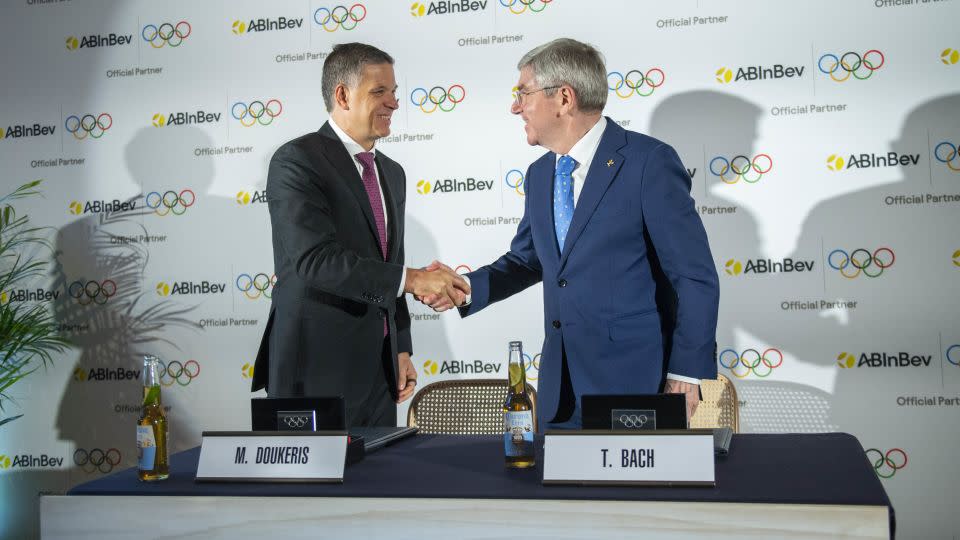 AB InBev CEO Michel Doukeris and IOC President Thomas Bach shake hands during an announcement event in London. - Stuart C. Wilson/Getty Images for AB InBev