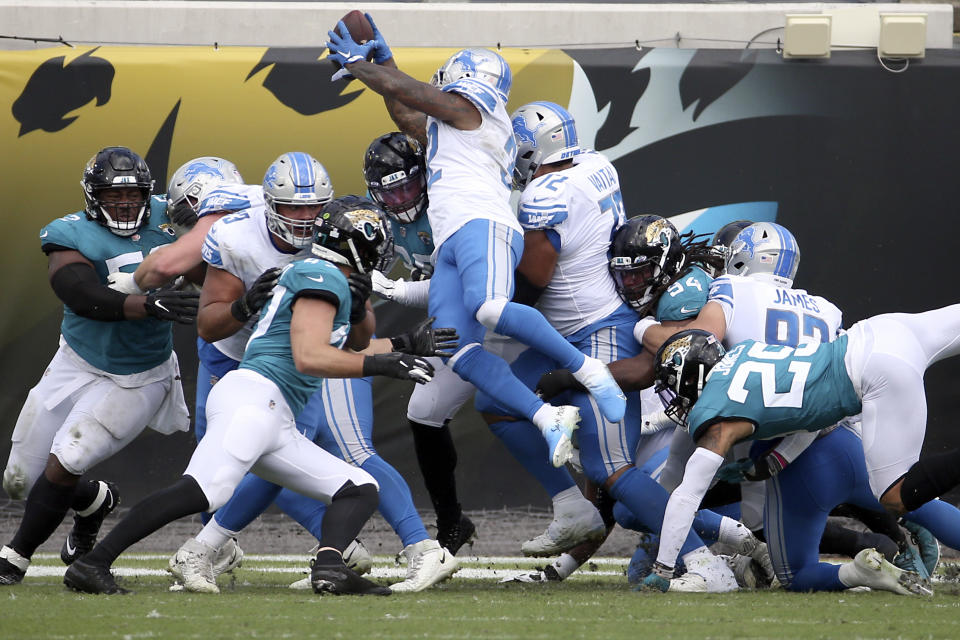 Detroit Lions running back D'Andre Swift, center, leaps over the line for a 1-yard touchdown against the Jacksonville Jaguars during the first half of an NFL football game, Sunday, Oct. 18, 2020, in Jacksonville, Fla. (AP Photo/Stephen B. Morton)