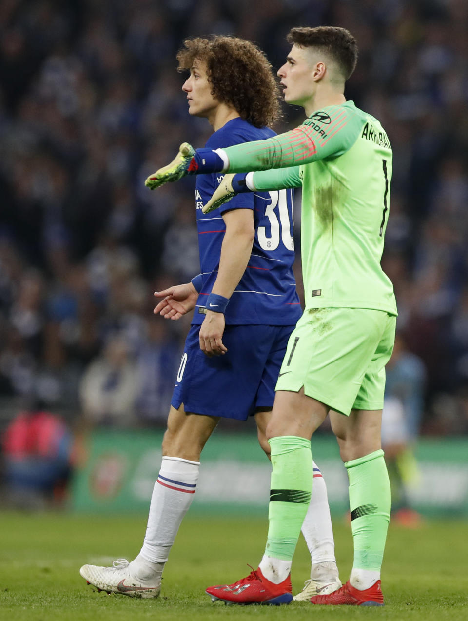 Chelsea's David Luiz, left, walks past Chelsea goalkeeper Kepa Arrizabalaga, right, during the English League Cup final soccer match between Chelsea and Manchester City at Wembley stadium in London, England, Sunday, Feb. 24, 2019. (AP Photo/Alastair Grant)