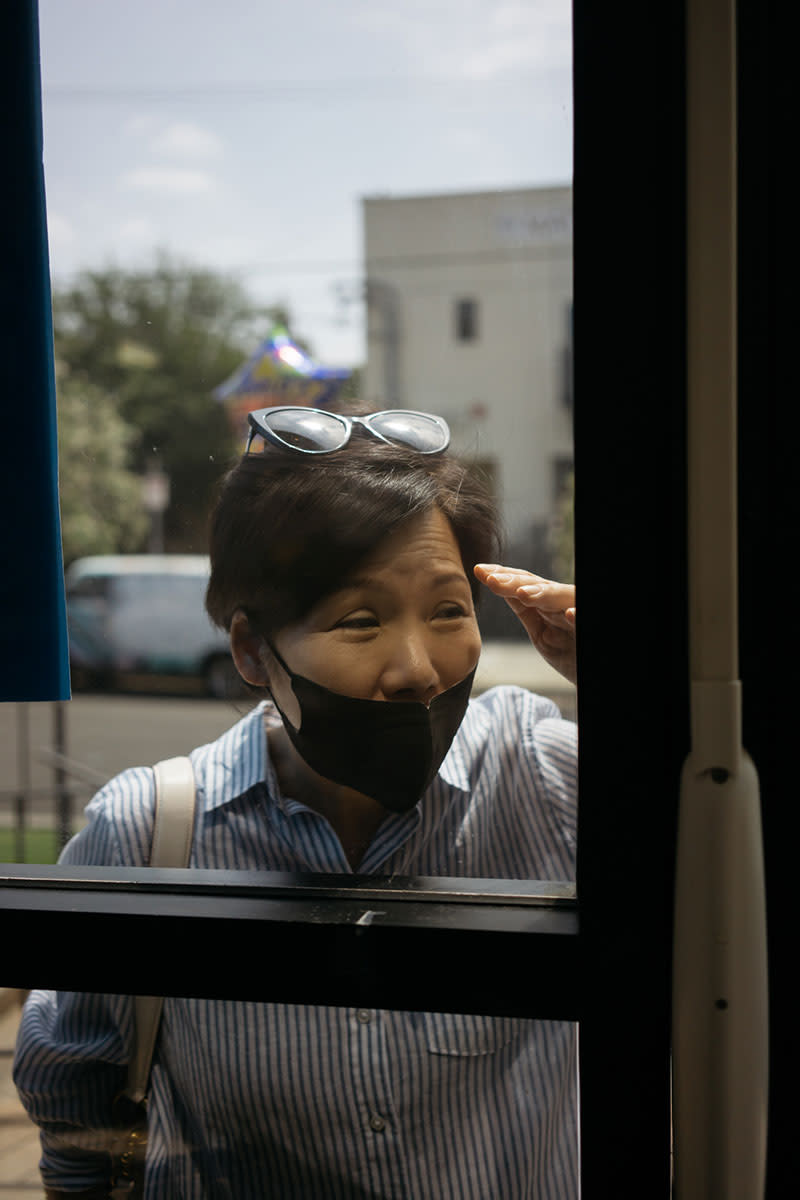 Lydia Yang visits her father, Noh Park, through the front window. | Isadora Kosofsky for TIME
