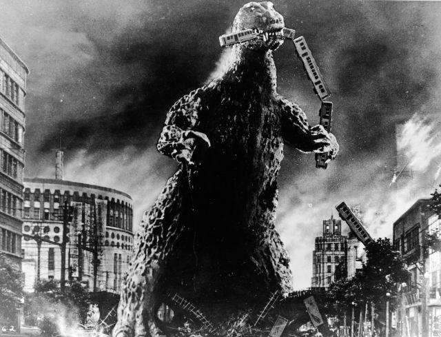 Radioactive monster Godzilla stomps through a city and eats a commuter train in a scene from 'Godzilla, King of the Monsters!,' directed by Ishiro Honda and Terry O. Morse, 1956