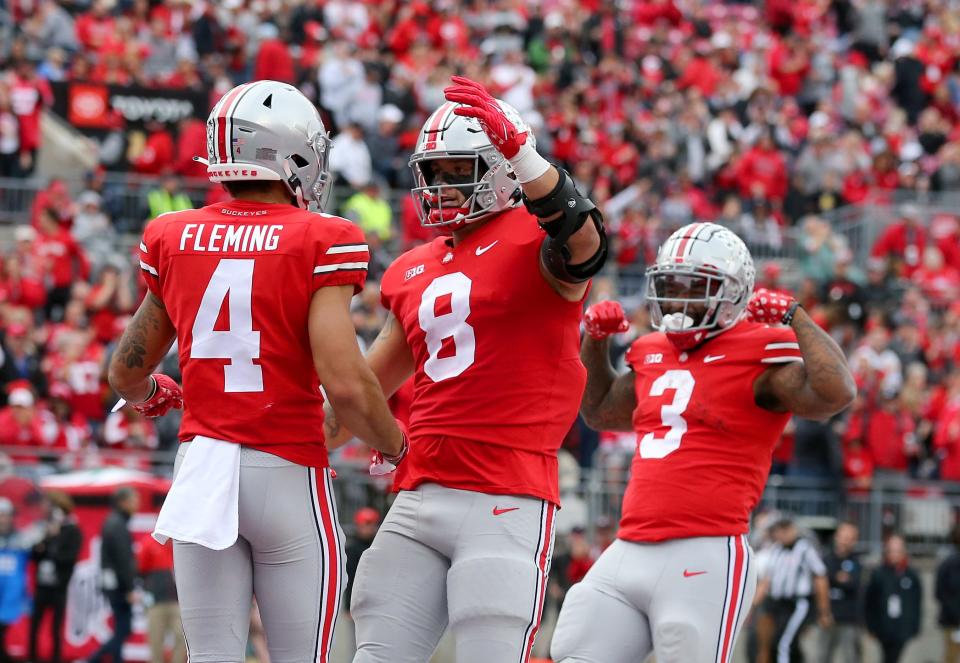 Ohio State wide receiver Julian Fleming (4) celebrates a touchdown catch with tight end Cade Stover (8) and running back Miyan Williams (3) during the second quarter against Rutgers.