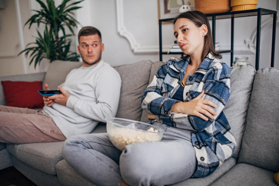 couple ignoring each other on the couch