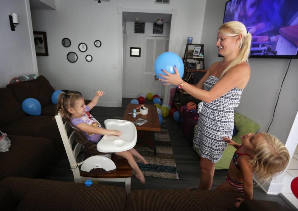 Ashley Grant tosses a balloon with daughter Brooklyn before the birthday party Brooklyn shared with her sister, Addy Stromquist.