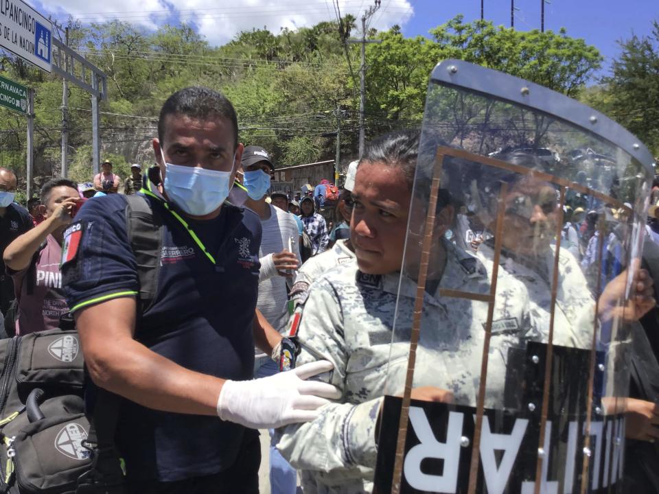 Female members of the National Guard are escorted by paramedics after being released by demonstrators, a day after being kidnapped while attempting to disperse a protest, in Chilpancingo, Mexico, Tuesday, July 11, 2023. According to officials the large demonstration that blocked the main highway and abducted several officials was organized by a drug gang aiming to force the government´s release of two detained gang leaders who have been charged with drug and weapons possession. (AP Photo/Alejandrino Gonzalez)