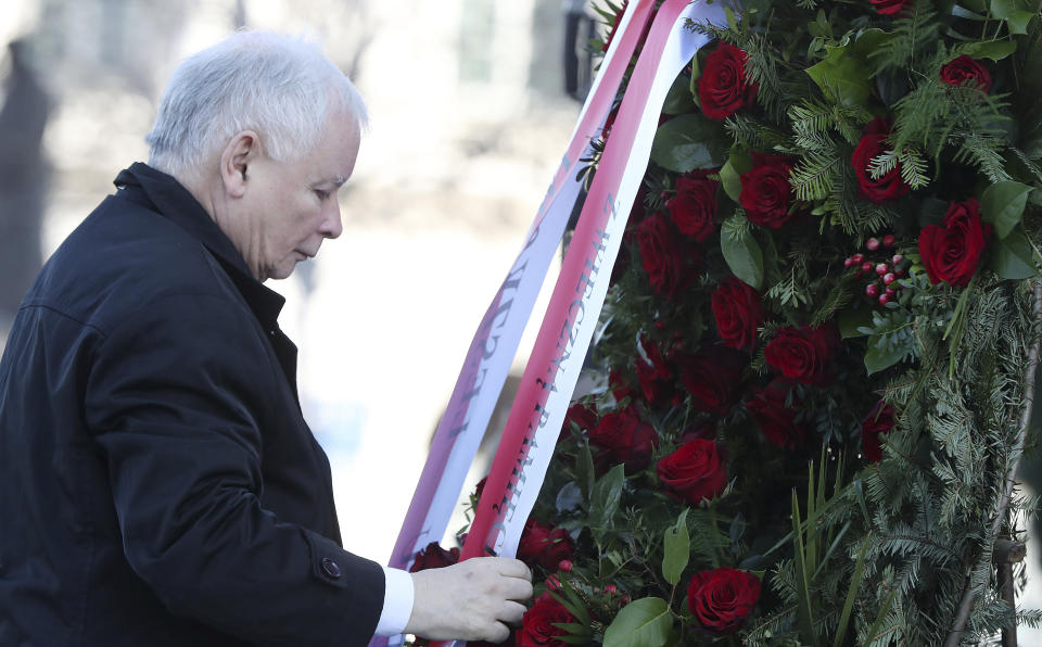 The head of Poland's ruling conservative party, Jaroslaw Kaczynski, lays down a wreath during a scaled-down observance in memory of his twin brother, the late President Lech Kaczynski, and 95 other prominent Poles who were killed in a plane crash in Russia 10 years ago, at the late president's monument in Warsaw, Poland, on Friday, April 10, 2020. The observances were scaled down to just a few people and no crowd, under social distancing regulations against the spread of the coronavirus. The new coronavirus causes mild or moderate symptoms for most people, but for some, especially older adults and people with existing health problems, it can cause more severe illness or death.(AP Photo/Czarek Sokolowski)