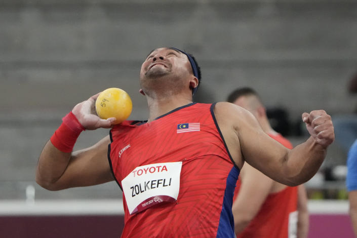 FILE - In this Tuesday, Aug. 31, 2021, file photo, Muhammad Ziyad Zolkefli of Malaysia competes in the men's shot put F20 final during the Tokyo 2020 Paralympics Games at the National Stadium in Tokyo. Zolkefli appeared to have won gold in the shot put in the F20 class. But after the victory on Tuesday, he was disqualified because he had shown up late for the competition. (AP Photo/Eugene Hoshiko, File)