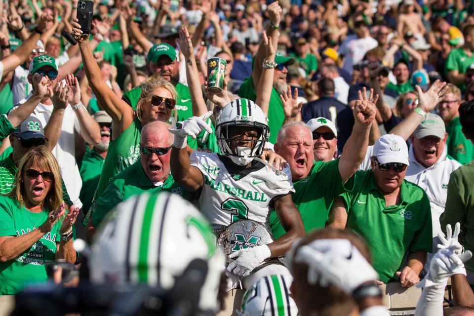 Marshall defensive back Steven Gilmore (3) jumps into the stands after returning an interception for a score against Notre Dame during an NCAA college football game Saturday, Sept. 10, 2022, in South Bend, Ind. Marshall won 26-21. (Sholten Singer/The Herald-Dispatch via AP)
