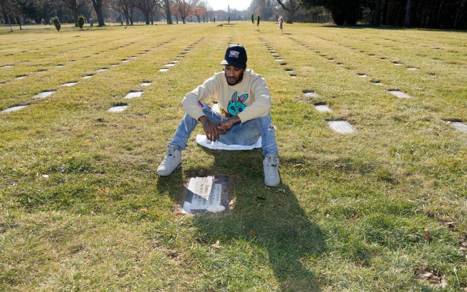 Justin Johnson sits by his daughter's grave at Graceland Cemetery in Milwaukee. Amillianna Ramirez-Johnson was 1 day old when she died on Sept. 19, 2021, at Ascension Columbia St. Mary's hospital.