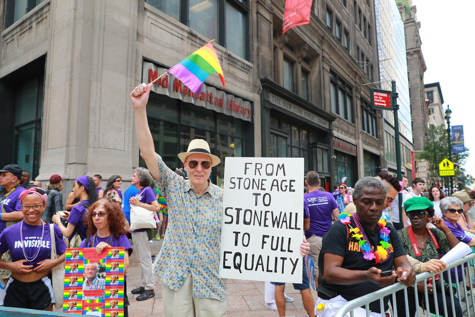 <p>A flag-bearing man holds up a sign during the N.Y.C. Pride Parade in New York on June 25, 2017. (Photo: Gordon Donovan/Yahoo News) </p>