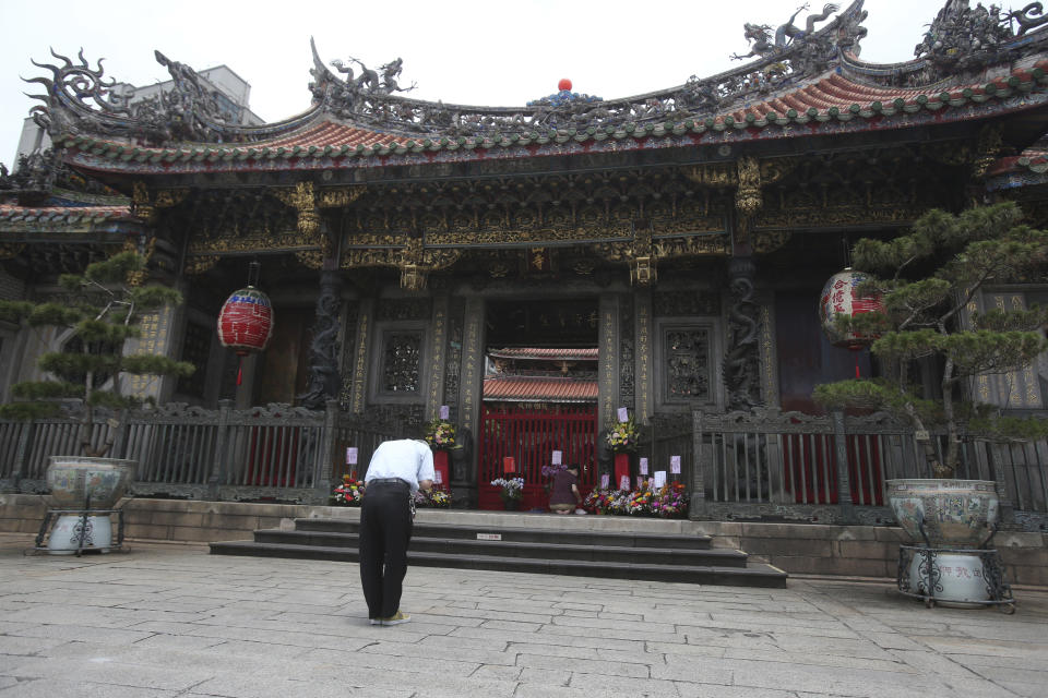 A visitor prays outside of Longshan Temple after the COVID-19 alert raise to level 3 in Taipei, Taiwan, Tuesday, May 18, 2021. (AP Photo/Chiang Ying-ying)