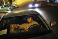 Alexei, an animal activist who would only give his first name, pets a stray half-breed Labrador he just picked up as he waits to meet up with his wife, his accomplice on this rescue mission, Monday, Feb. 10, 2014, in Sochi, Russia, home of the 2014 Winter Olympics. Alexei is one of a dozen people in the emerging movement of animal activists in Sochi alarmed by reports that the city has contracted the killing of thousands of stray dogs before and during the Olympic Games. Stray dogs are a common sight on the streets of Russian cities, but with massive construction in the area the street dog population in Sochi and the Olympic park has soared. Useful as noisy, guard dogs, workers feed them to keep them nearby and protect buildings. They soon lose their value and become strays. Tonight, a few dogs will be taken on their way to a new life in Moscow. (AP Photo/David Goldman)