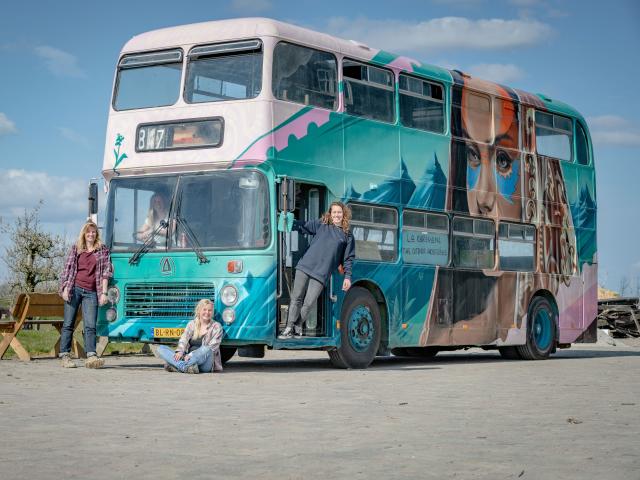 the exterior of the double decker bus with the four women