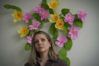 Artist and puppeteer Katayoun Amir-Aslani stands for a portrait next to her floral art creation in New York on Friday, April 9, 2021. The artwork signals "re-birth and new beginnings," said Amir-Aslani. Balance, harmony and wholeness. That's how I feel now." Amir-Aslani left Gettysburg College after a sexual assault in the spring of 2014. (AP Photo/Bebeto Matthews)