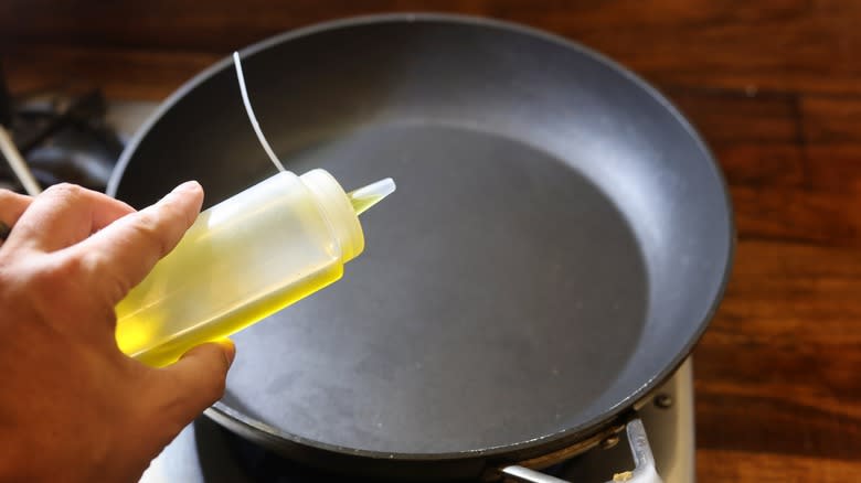 adding oil to skillet