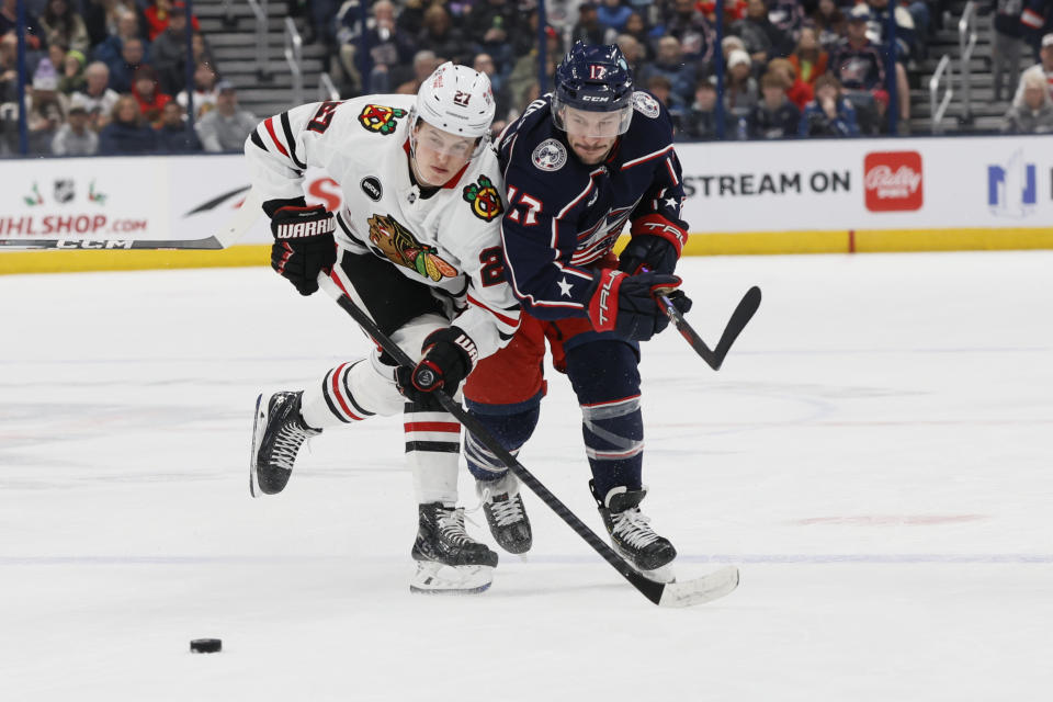 Chicago Blackhawks' Lukas Reichel, left, and Columbus Blue Jackets' Justin Danforth chase the puck during the first period of an NHL hockey game Wednesday, Nov. 22, 2023, in Columbus, Ohio. (AP Photo/Jay LaPrete)