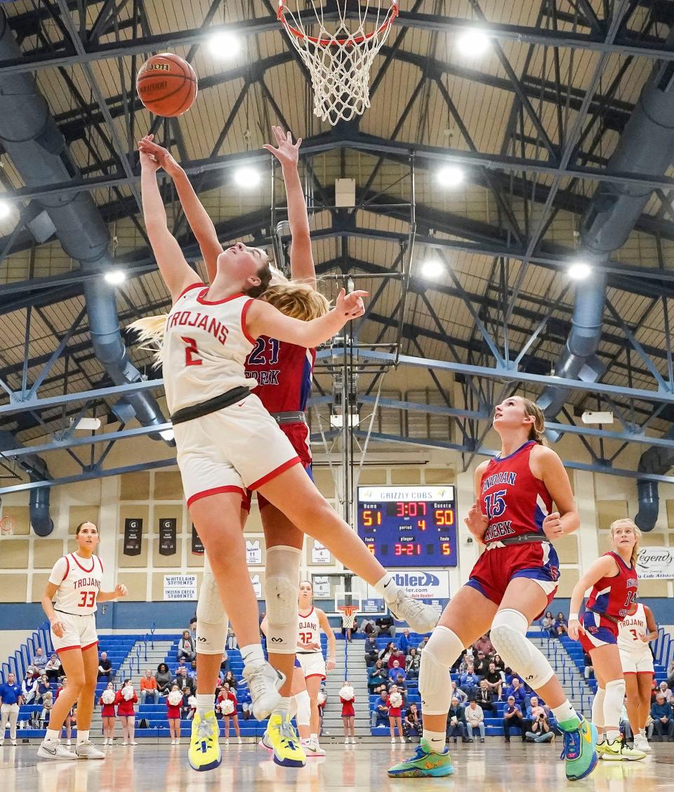 Center Grove Trojans Audrey Annee (2) for a lay-up against Indian Creek Faith Wiseman (21) on Thursday, Nov. 16, 2023, during the semifinals of the Johnson County Tournament at Franklin Community High School in Franklin. The Center Grove Trojans defeated Indian Creek, 61-52.
