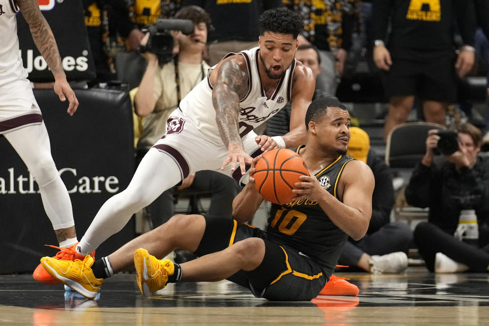 Missouri's Nick Honor, bottom, looks to pass as Texas A&M's Jace Carter, top, defends during the first half of an NCAA college basketball game Wednesday, Feb. 7, 2024, in Columbia, Mo. (AP Photo/Jeff Roberson)