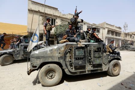 Iraqi Federal Police members ride in a military vehicle during fighting between Iraqi forces and Islamic State militants in the Old City of Mosul, Iraq July 4, 2017. REUTERS/Ahmed Saad