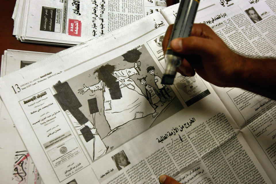 GUANTANAMO BAY, CUBA - OCTOBER 27: (EDITORS NOTE: Image has been reviewed by U.S. Military prior to transmission.) An Arabic translator censors out selected images and news articles from a newspapers before detainees are permitted to read them inside the U.S. military prison for "enemy combatants" on October 27, 2009 in Guantanamo Bay, Cuba. Although U.S. President Barack Obama pledged in his first executive order last January to close the infamous prison within a year's time, the government has been struggling to try the accused terrorists and to transfer them out ahead of the deadline. Military officials at the prison point to improved living standards and state of the art medical treatment available to detainees, but the facility's international reputation remains tied to the "enhanced interrogation techniques" such as waterboarding employed under the Bush administration. (Photo by John Moore/Getty Images)