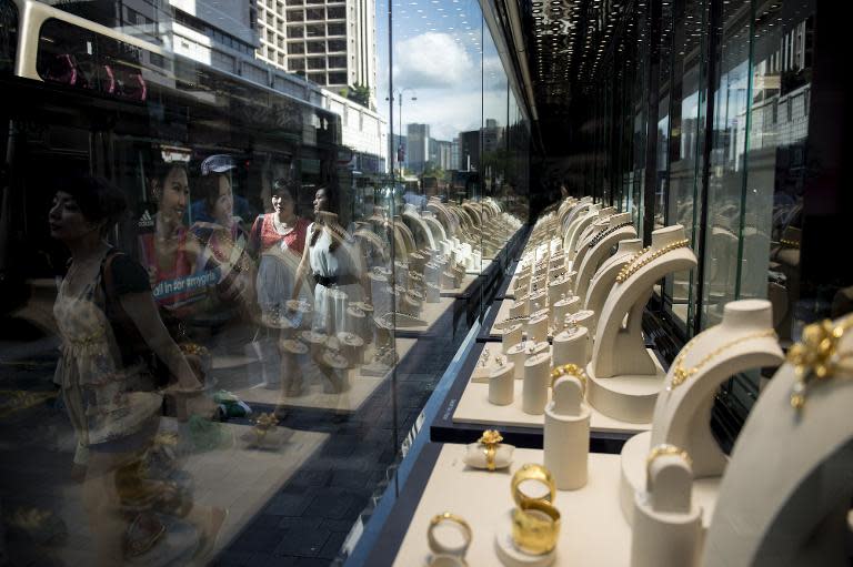 People are seen passing by a jewellery store in Hong Kong, on August 8, 2014