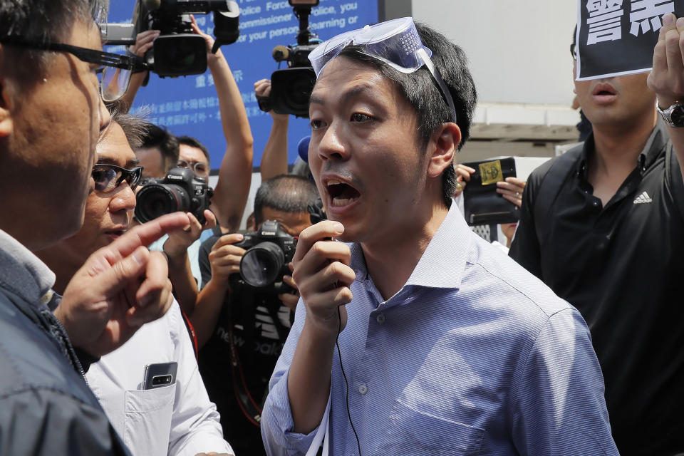 FILE - Hong Kong pro-democracy lawmaker Ted Hui, center, argues with pro-Beijing lawmaker Junius Ho, left, during a demonstration in Hong Kong on Aug. 12, 2019. Hong Kong's leader said Tuesday, July 4, 2023, that eight pro-democracy activists who now live in the United States, Britain, Canada and Australia will be pursued for life for alleged national security offenses, dismissing criticism that the move to have them arrested was a dangerous precedent. (AP Photo/Kin Cheung, File)