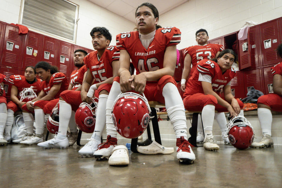 Lahainaluna High School football team players listens to co-head coach Dean Rickard before their homecoming game at Sue D. Cooley Stadium, Saturday, Oct. 21, 2023, in Lahaina, Hawaii. Lahainaluna’s varsity and junior varsity football teams are getting back to normal since the devastating wildfire in August. (AP Photo/Mengshin Lin)