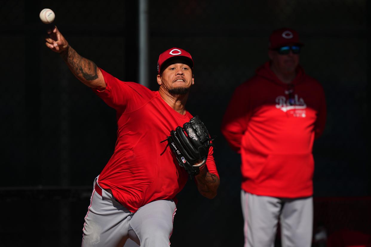 Cincinnati Reds starting pitcher Frankie Montas (47) throws in the bullpen as Cincinnati Reds pitching coach Derek Johnson observes during spring training workouts, Wednesday, Feb. 14, 2024, at the team’s spring training facility in Goodyear, Ariz.