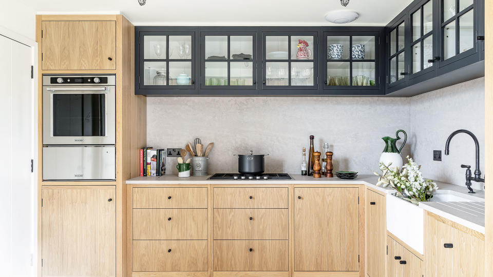  wooden cabinets in neutral kitchen with large sink and microwave 