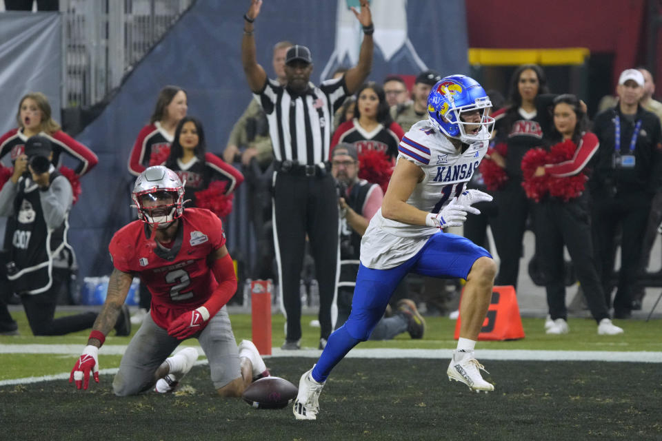 Kansas wide receiver Luke Grimm (11) celebrates a touchdown against UNLV during the second half of the Guaranteed Rate Bowl NCAA college football game Tuesday, Dec. 26, 2023, in Phoenix. Kansas won 49-36. (AP Photo/Rick Scuteri)