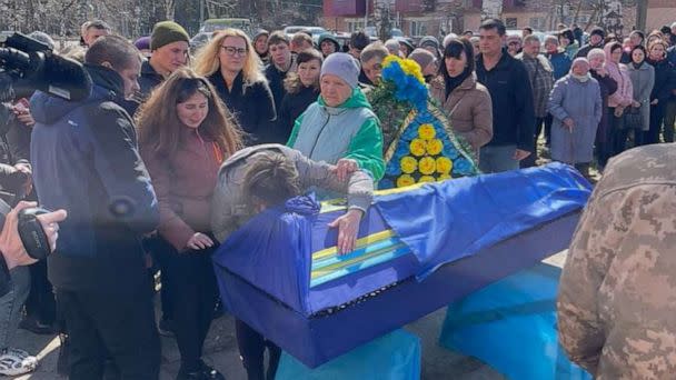 PHOTO: Tetyana Taranukha hugging the coffin of her son, Yuriy Taranukha, at his funeral in their home town of Zmiiv in the Kharkiv region. (Tom Soufi Burridge/ABC News)