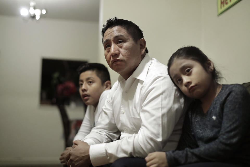 In this Nov. 21, 2019, photo Audencio Lopez, center, who crossed the border illegally as a teenager in 1997, is seated with two of his children, Anaias, 12, left, and Mercy, 8, right, during an interview with The Associated Press, at their home in Lynn, Mass. After going through the immigration court process for seven years, Lopez was told at a court hearing this past fall that the government won’t oppose granting him a visa due to his “exemplary” record and community service. But Lopez admits the family’s joy is tempered by uncertainty because his wife’s immigration status remains unresolved. (AP Photo/Steven Senne)