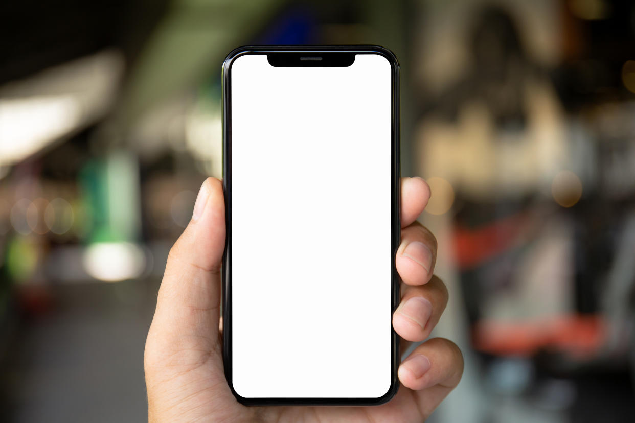 man hand holding phone with isolated screen on the background of a city street