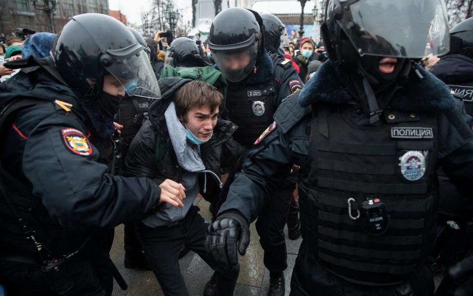 Police officers detain a man during a protest against the jailing of Mr Navalny on January 23 - Pavel Golovkin /AP