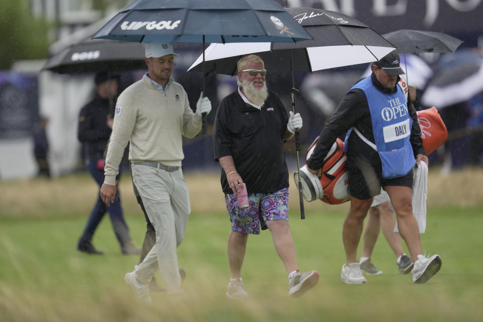 United States' John Daly, centre walks with United States' Bryson DeChambeau, left on the 3rd fairway during a practice round for the British Open Golf Championships at the Royal Liverpool Golf Club in Hoylake, England, Tuesday, July 18, 2023. The Open starts Thursday, July 20. (AP Photo/Kin Cheung)
