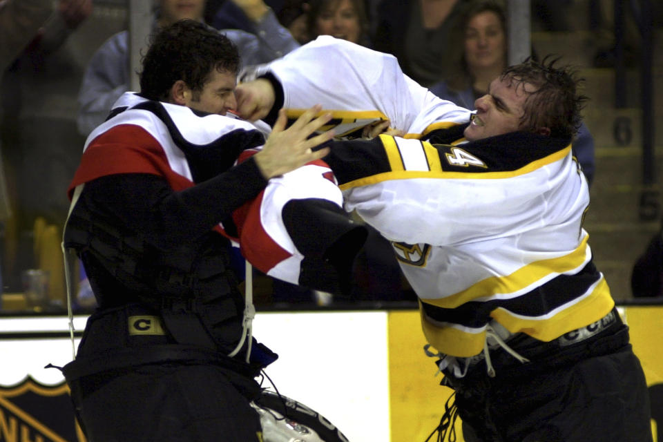 FILE - Boston Bruins goalie Byron Dafoe, right, lands a right to the face of Ottawa Senators goalie Patrick Lalime during the third period in Boston, Jan. 17, 2002. The league rule changes have made it so punitive that goalie fighting has essentially disappeared from the highest level of hockey. (AP Photo/Robert E. Klein, File)