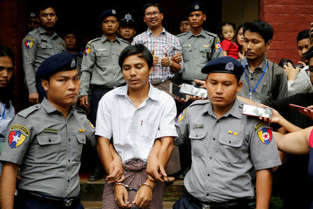 Detained Reuters journalist Kyaw Soe Oo and Wa Lone are escorted by police as they leave after a court hearing in Yangon, Myanmar, August 20, 2018. REUTERS/Ann Wang/Files