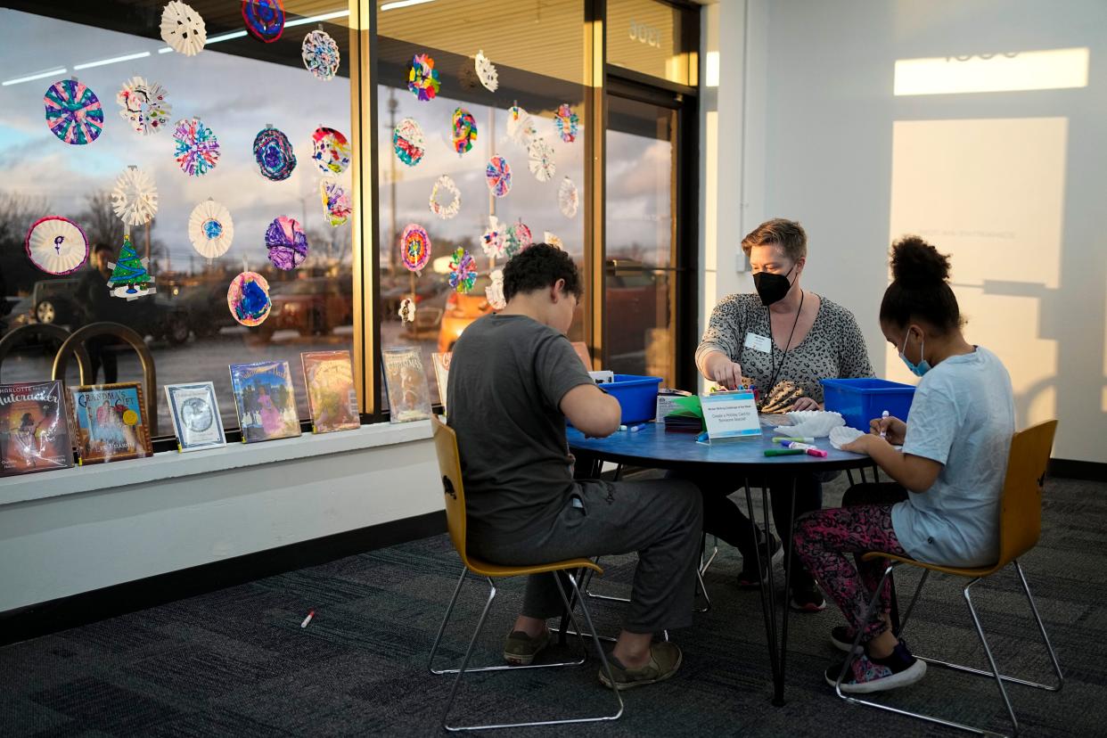 As part of the Columbus Metropolitan Library system's Winter Reading Challenge, Ethan Austin and Savayah Singletary, both 10, create snowflakes and holiday messages out of a coffee filter and craft supplies with services manager Michelle Garver on Dec. 15 at the Reynoldsburg branch.