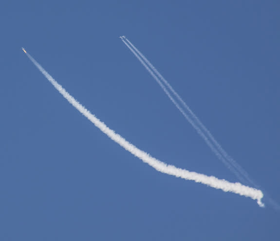 Virgin Galactic's SpaceShipTwo rises into the sky under rocket power on Sept. 5, 2013. At right is WhiteKnightTwo, the private space plane's mothership, which carried it into the sky.