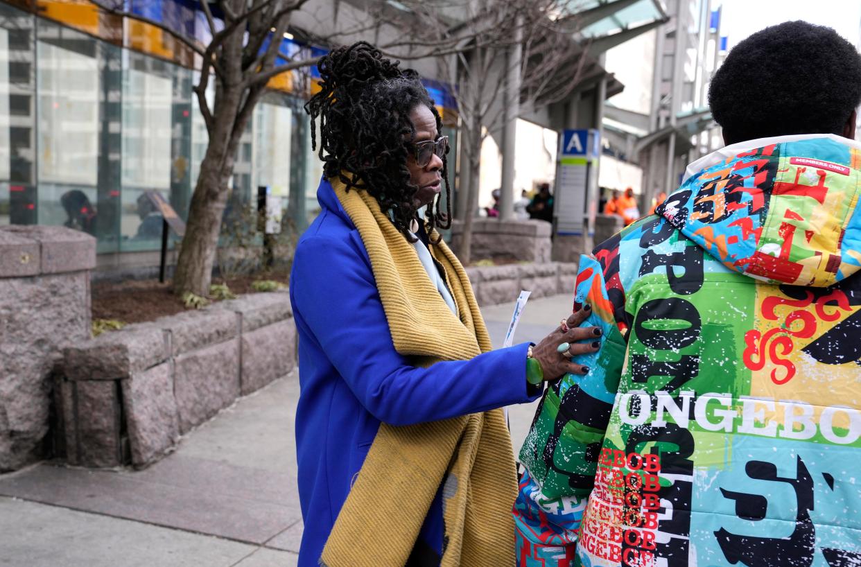 Community activist Iris Roley speaks with a student about youth programs that are offered in Cincinnati, as he walks through Government Square on Thursday.