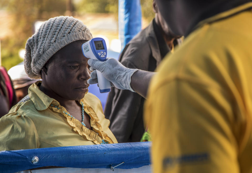 In this photo provided by the International Rescue Committee, a Congolese refugee is screened for Ebola symptoms at the IRC triage facility in the Kyaka II refugee settlement in Kyegegwa District in western Uganda, Thursday, June 13, 2019. The Congolese pastor who is thought to have caused the Ebola outbreak's spread into Uganda was unknown to health officials before he died of the disease, the World Health Organization's emergencies chief said Thursday, underlining the problems in tracking the virus. (Kellie Ryan/International Rescue Committee via AP)