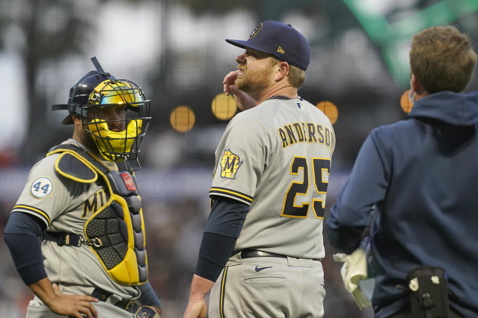 Milwaukee Brewers pitcher Brett Anderson (25) stands next to catcher Omar Narvaez after being struck by the ball on a single by San Francisco Giants' Brandon Crawford during the second inning of a baseball game in San Francisco, Wednesday, Sept. 1, 2021. (AP Photo/Jeff Chiu)