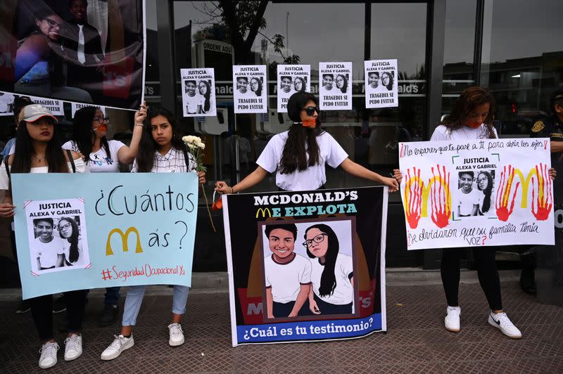 People protest outside of a closed McDonald's restaurant, after the the deaths of two teenaged employees, in Lima