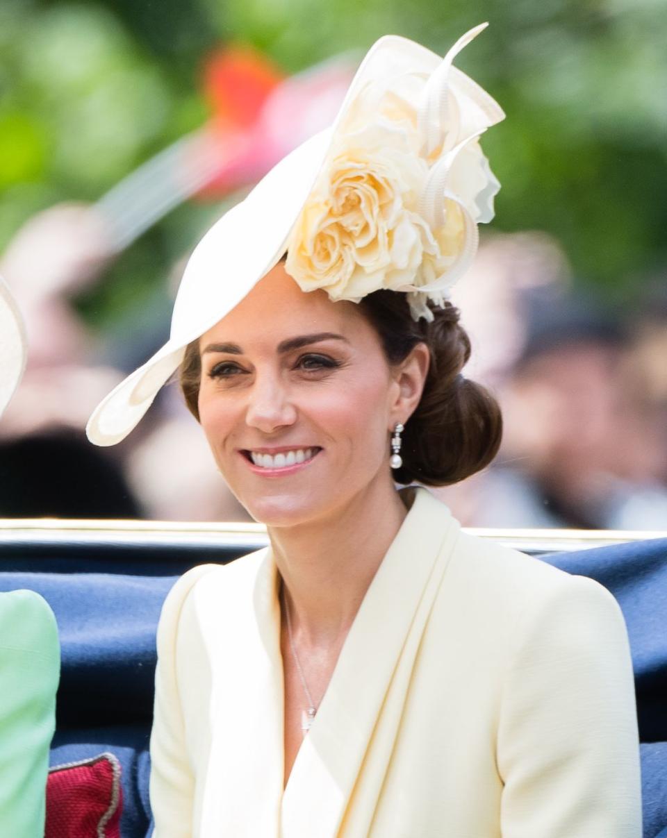 <p>In addition to adding a pulled-together touch, Kate also uses the low bun style to accent hair accessories, like this floral hat she wore for Trooping The Colour on June 08, 2019.</p>