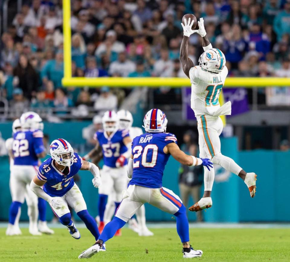 Miami Dolphins wide receiver Tyreek Hill (10) catches the ball as Buffalo Bills safety Taylor Rapp (20) looks to tackle in the second quarter of an NFL game at Hard Rock Stadium on Sunday, Jan. 7, 2023, in Miami Gardens Fla.