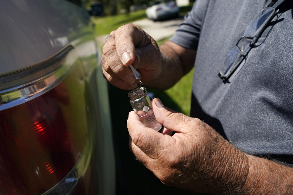 Water plant operator Mike Gandy takes a water sample of the Ferriday water system from a neighborhood in neighboring Ridgecrest, La., which is now in the Ferriday system, Tuesday, Sept. 13, 2022. The water is now tested regularly and plant operators are working on new treatment methods. (AP Photo/Gerald Herbert)