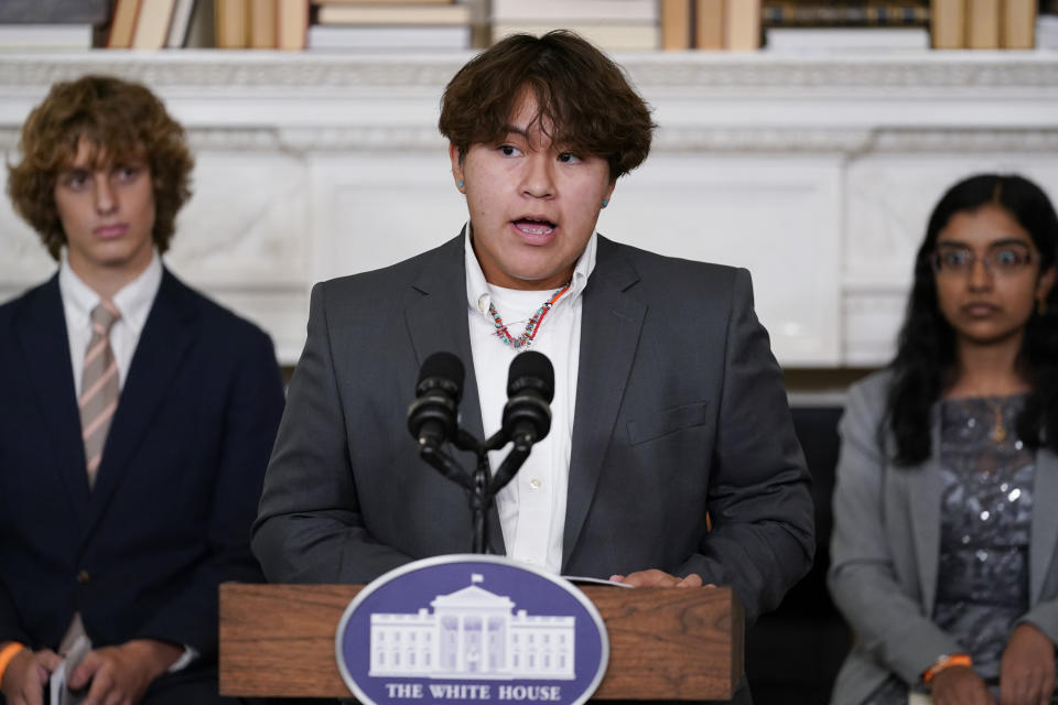 Jesse Begay from Santa Fe, N.M., reads his poem during event for the Class of 2022 National Student Poets hosted by first lady Jill Biden at the White House in Washington Tuesday, Sept. 27, 2022. Seated behind from left, Winslow Hastie, Jr., from Charleston, S.C., and Vidhatrie Keetha, from the Bronx borough of New York. (AP Photo/Carolyn Kaster)